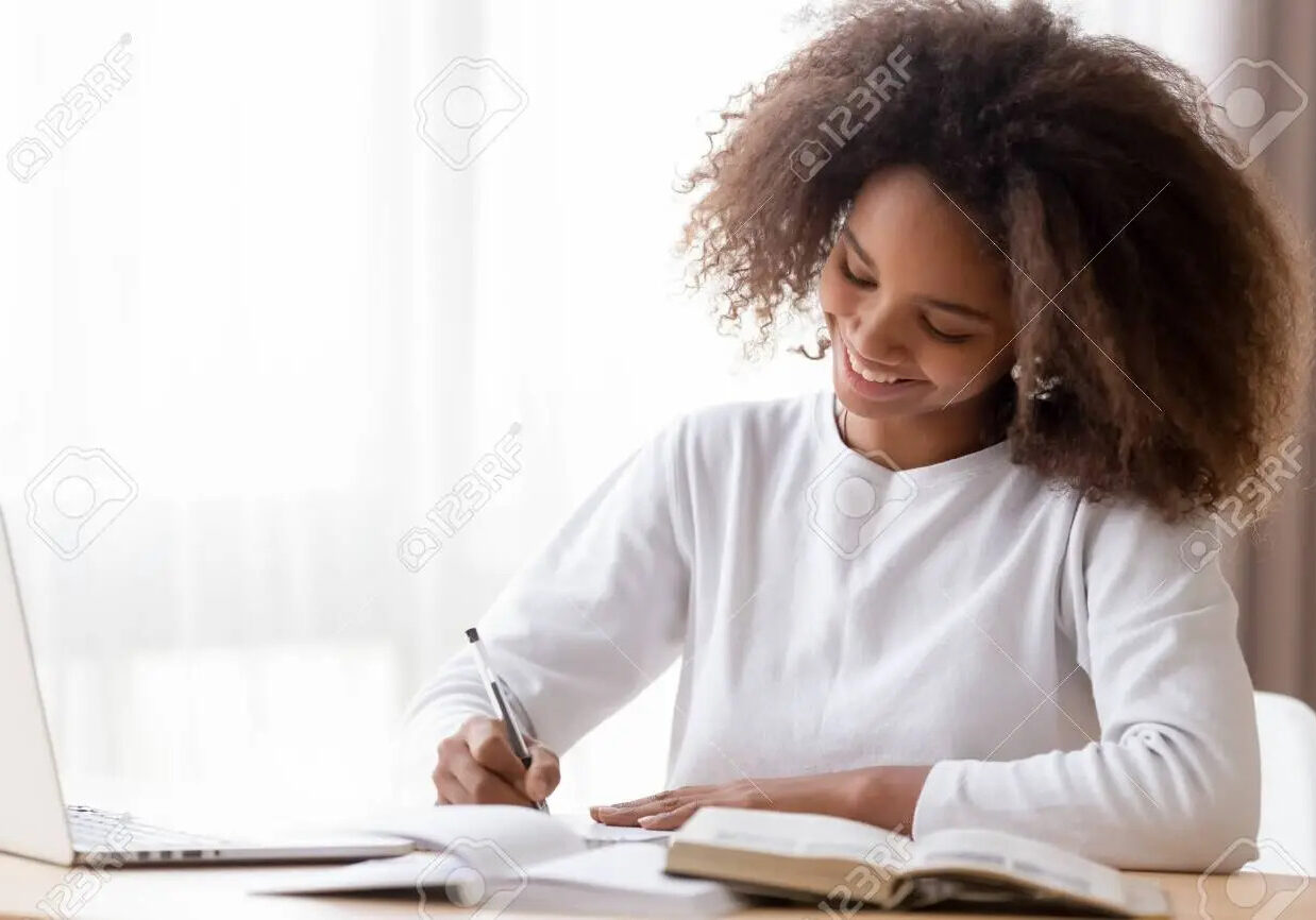 123628443-smiling-african-american-teen-girl-preparing-school-homework-using-laptop-happy-black-schoolgirl-pup