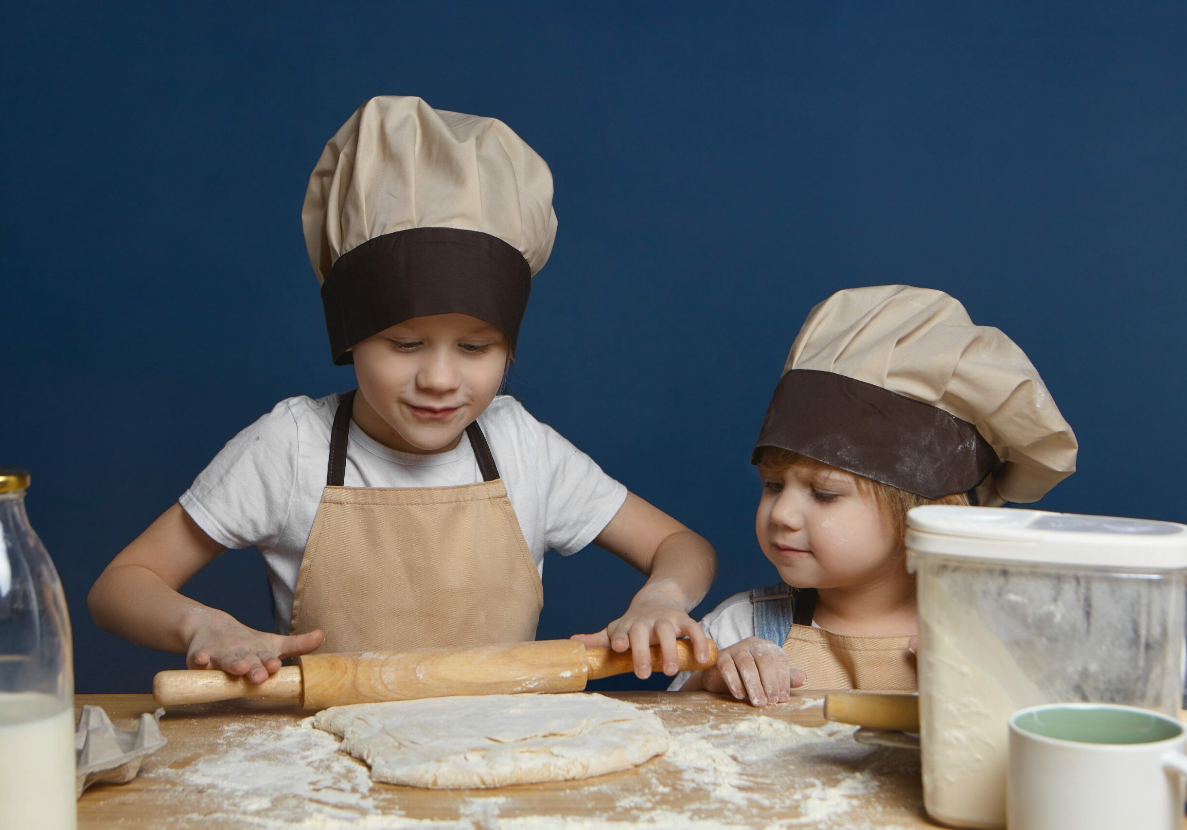 candid-shot-charming-little-girl-chef-hat-watching-her-elderly-brother-kneading-dough-cookies-pie-scaled-1.jpg